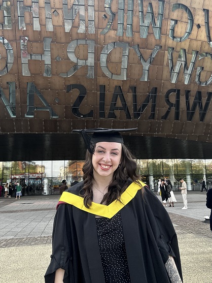 Beth Fry celebrates her graduation outside the Millennium Centre in Cardiff Bay