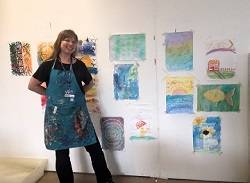 Community member poses with art made by participants