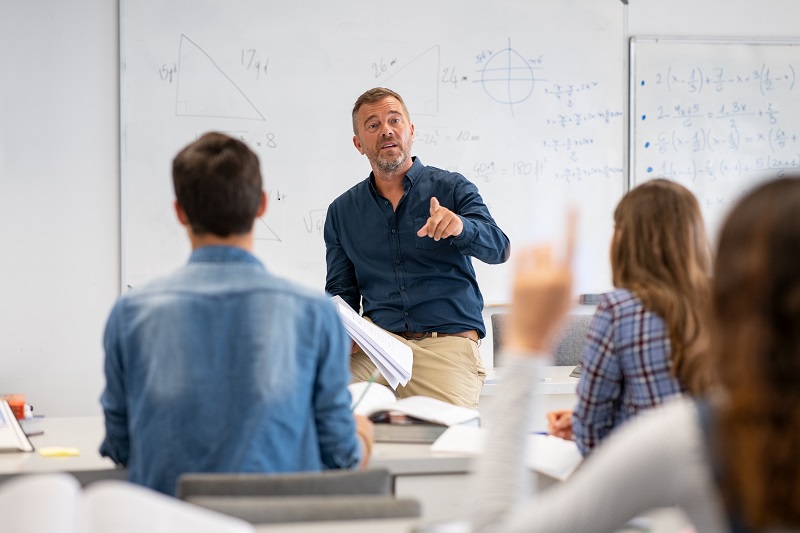 Teacher answer questions by pupils in the classroom