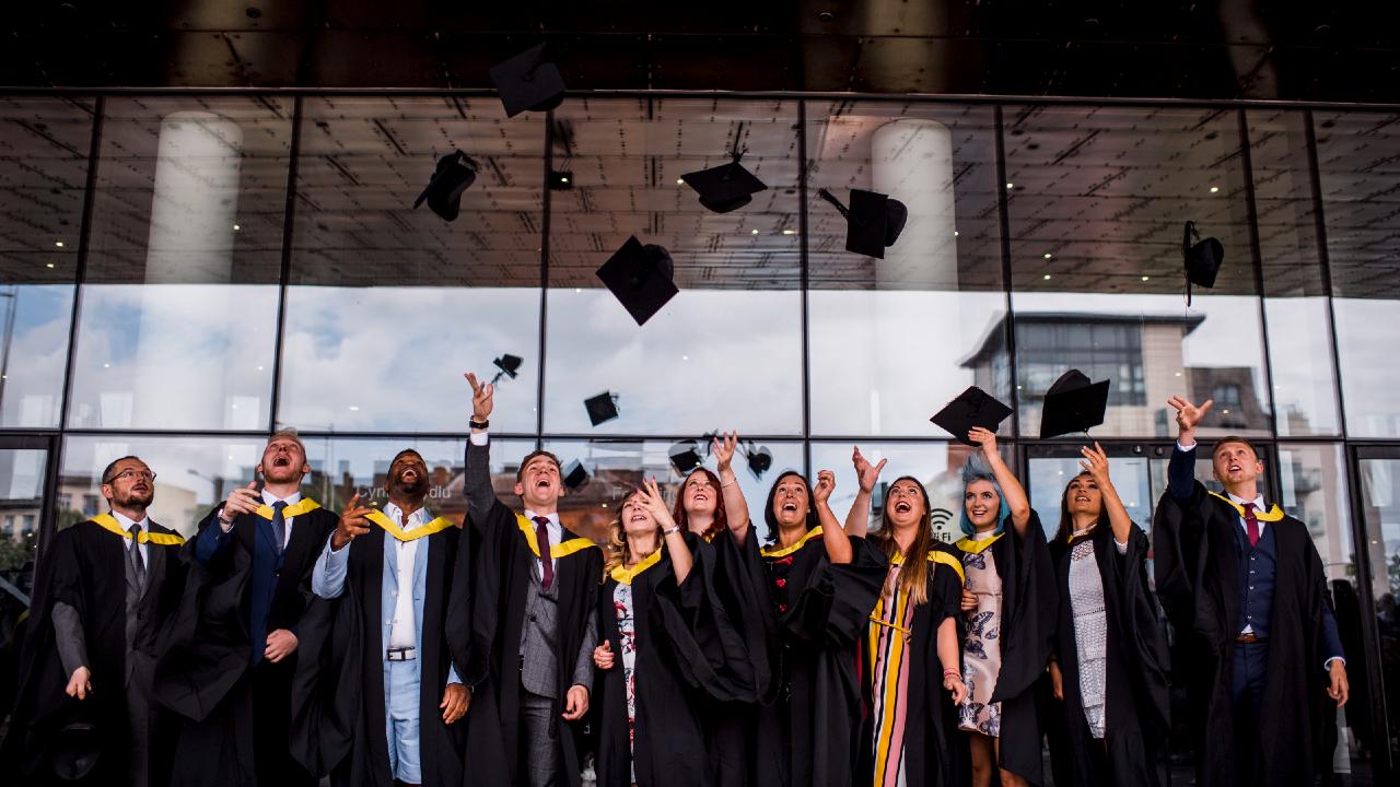 Graduating students throw hats in air