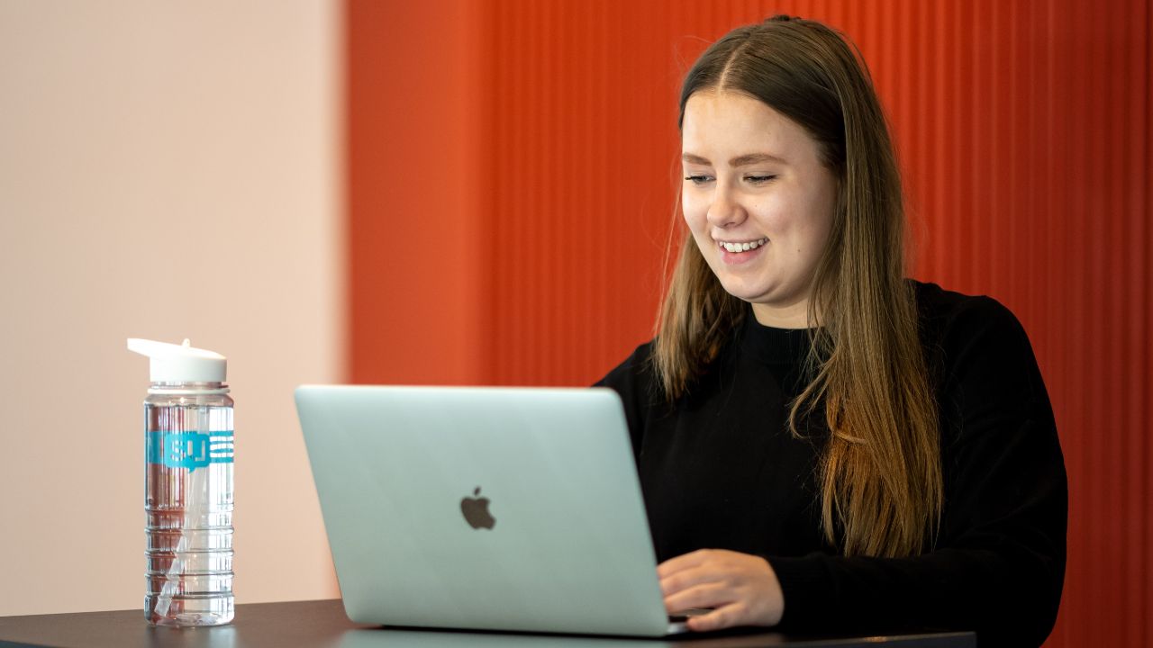 Smiling student looking at laptop